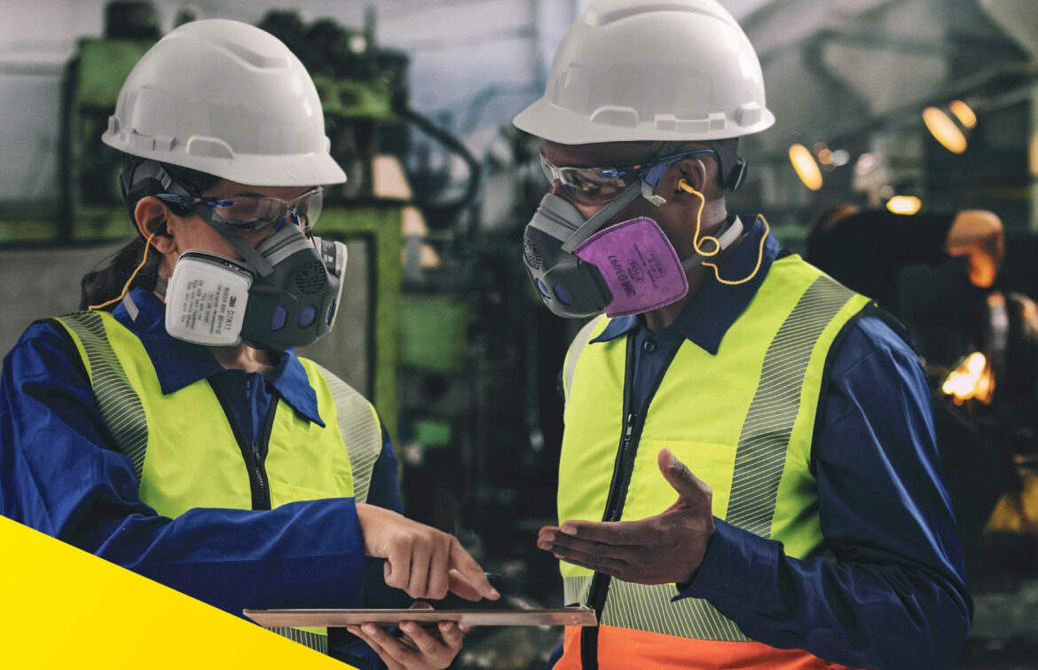 Pessoas usando respirador semifacial em uma indústria.